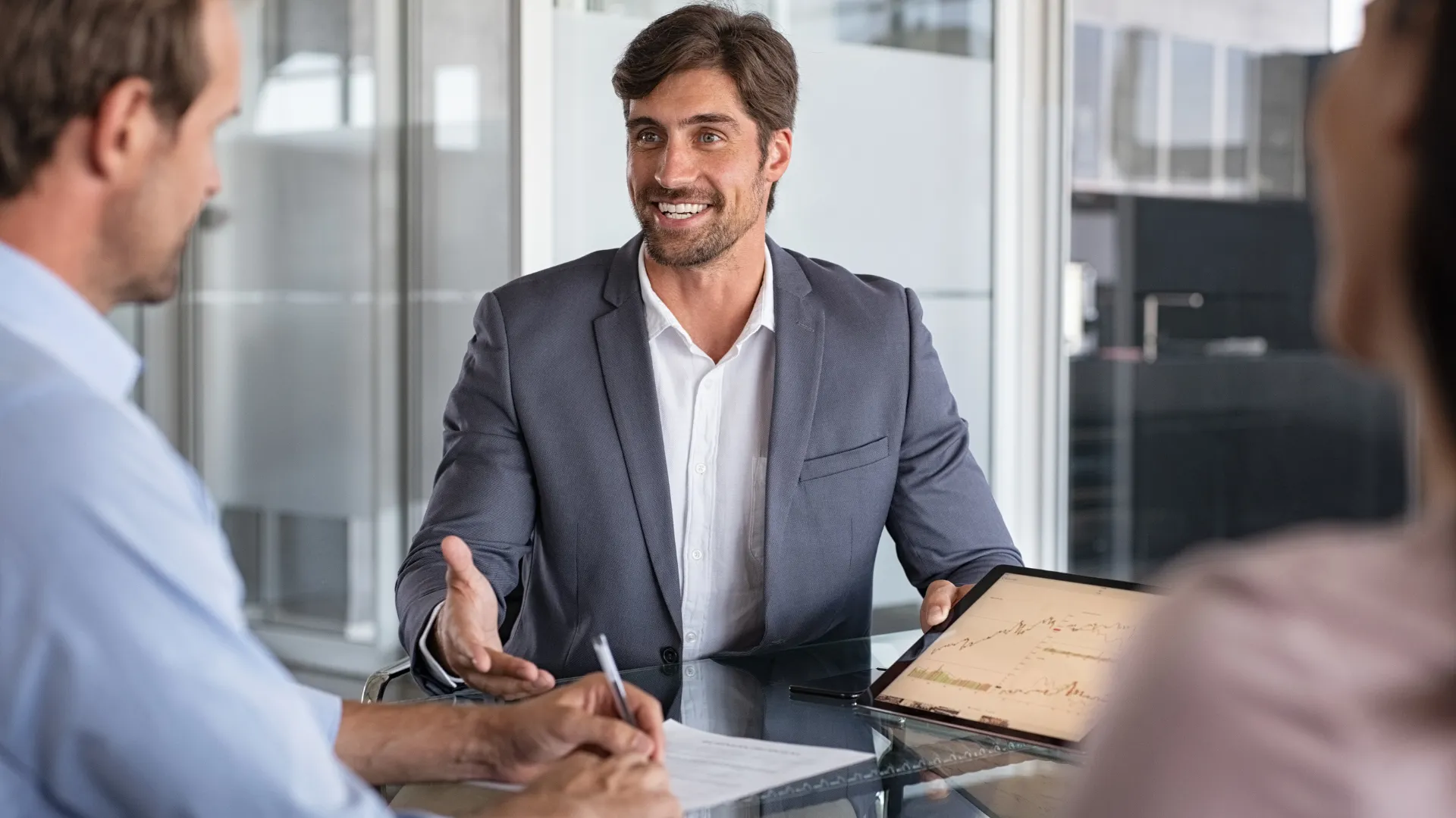 Financial advisor meeting with two clients in an office